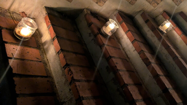 Kerzen in Gläsern stehen auf mehreren Treppenstufen